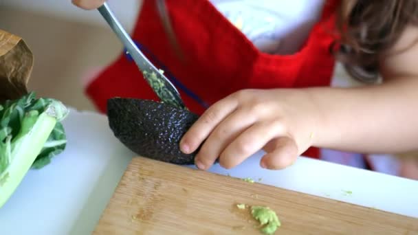 Женские руки, разбрасывающие авокадо на куске хлеба над доской — стоковое видео