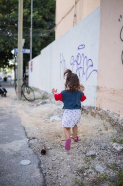 Bisiklete doğru koşan sevimli küçük kız ve ahşap sokak lambası direği