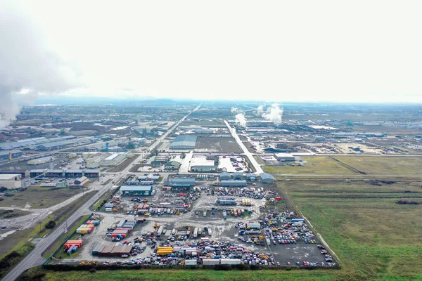 Industrial park surrounded by empty fields and under cloudy sky