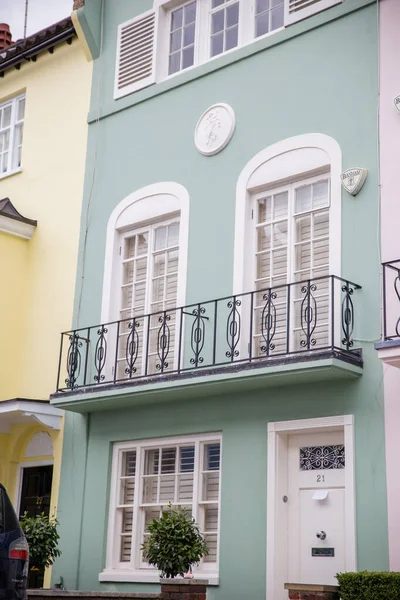 Light green British house with balconies and plants