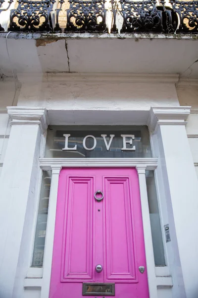 영국 백인 집의 분홍색 문 위에 사랑이라는 말 — 스톡 사진