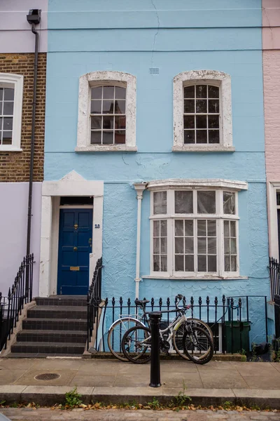 Blue British house with handrail and a bicycle parked outside Stock Photo