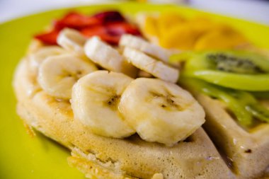 Üstünde meyve dilimleri olan sarı bir tabakta gözleme.