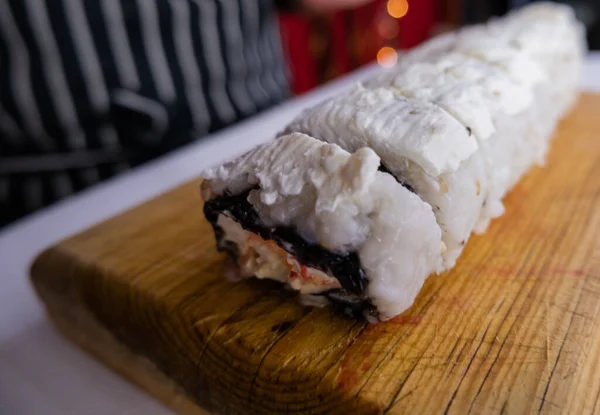 Sushi rolky pokryté bílým krémem na řezací desce — Stock fotografie