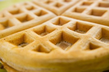Sarı bir tabakta taze yuvarlak waffle.