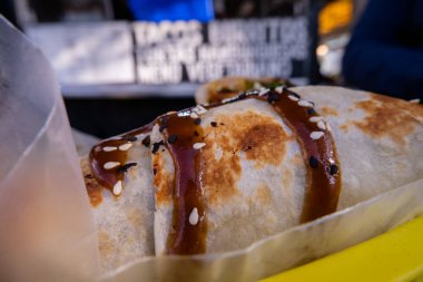 Sosla kaplı burritolar ve plastik bir sepette tohumlar.