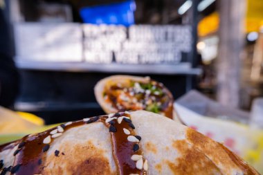 Sosla kaplı burritolar ve plastik bir sepette tohumlar.