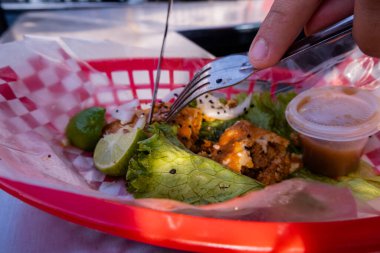 Plastik sepette vejetaryen kızarmış taco kesen eller.