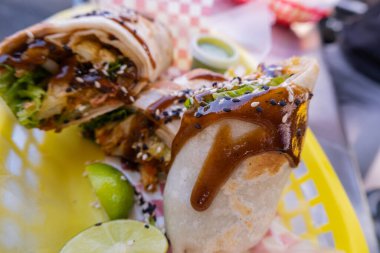 Sosla kaplı burritolar ve plastik bir sepette tohumlar.