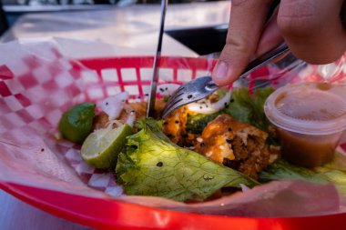 Plastik sepette vejetaryen kızarmış taco kesen eller.