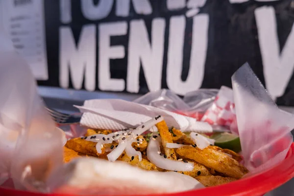 Frites et oignons sur un panier en plastique avec des mots derrière — Photo