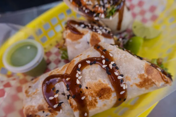 Burritos cubiertos con salsa y semillas en una canasta de plástico —  Fotos de Stock