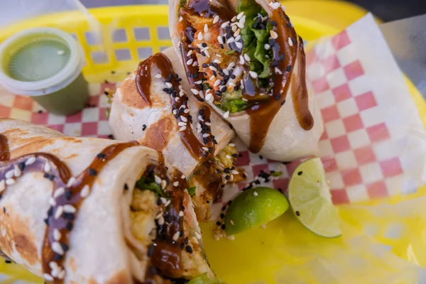 Burritos cubiertos con salsa y semillas en una canasta de plástico —  Fotos de Stock