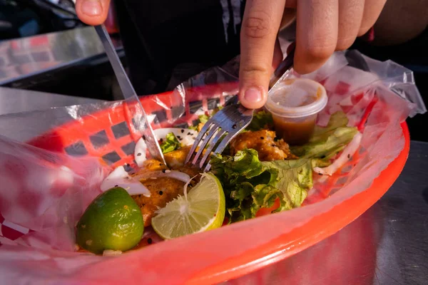 Mains coupant un taco végétarien frit sur panier en plastique — Photo