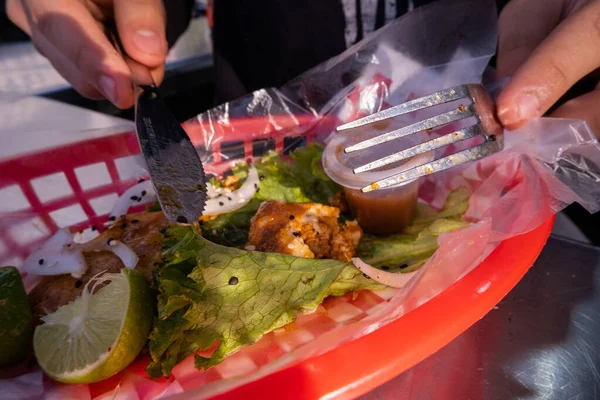 Mains coupant un taco végétarien frit sur panier en plastique — Photo