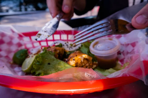 Mains coupant un taco végétarien frit sur panier en plastique — Photo