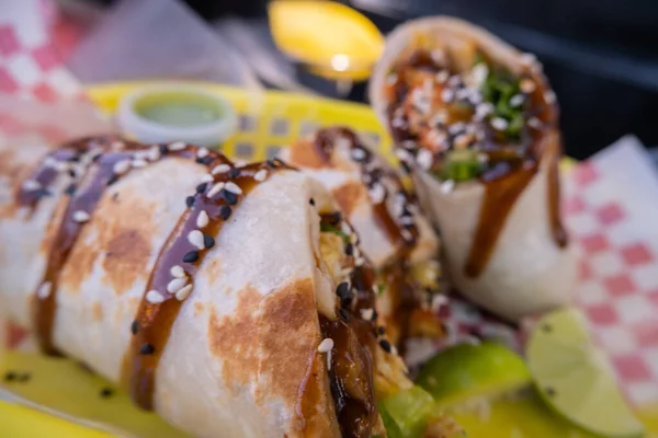 Burritos cubiertos con salsa y semillas en una canasta de plástico —  Fotos de Stock