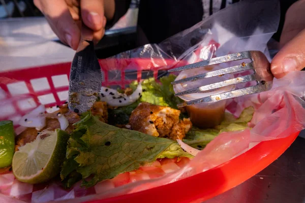 Mains coupant un taco végétarien frit sur panier en plastique — Photo