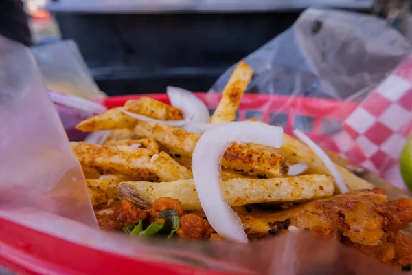 Frites et oignons sur un taco végétarien sur un panier en plastique — Photo