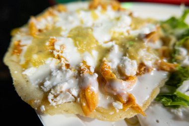 Beyaz tabakta sos, tavuk ve ekşi krema.