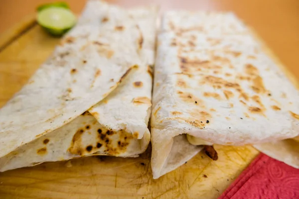 Quesadillas y una rodaja de lima en una tabla de cortar —  Fotos de Stock