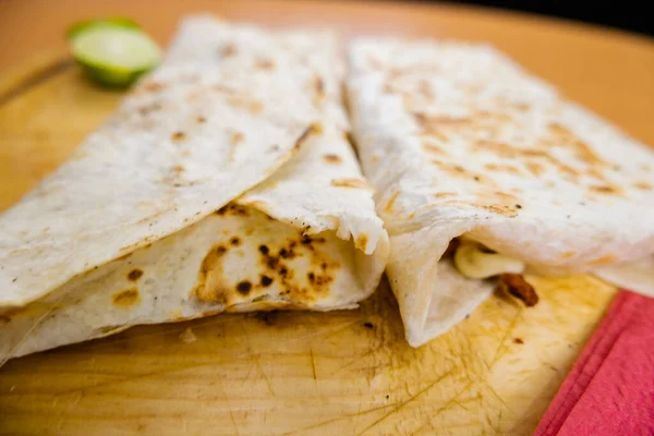 Quesadillas y una rodaja de lima en una tabla de cortar —  Fotos de Stock