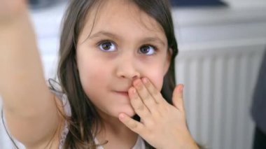 Sevimli küçük kız fıstık ezmesiyle bir dilim ekmek yiyor.