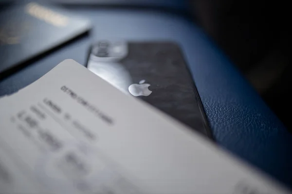 Flygbiljett och smartphone ovanför en mörkblå sits — Stockfoto