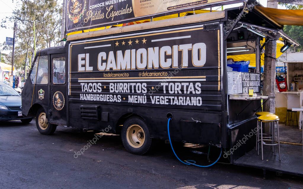 Mexico City, Mexico - February 14, 2020: Vegetarian food truck with the words Little truck, hamburgers, and vegetarian menu in Spanish. Black van selling vegan food in street. Food and restaurants
