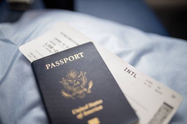Amerikan pasaportu ve uçak bileti bir koltuğun üstünde.