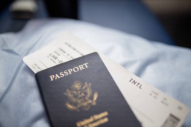 Amerikan pasaportu ve uçak bileti bir koltuğun üstünde.
