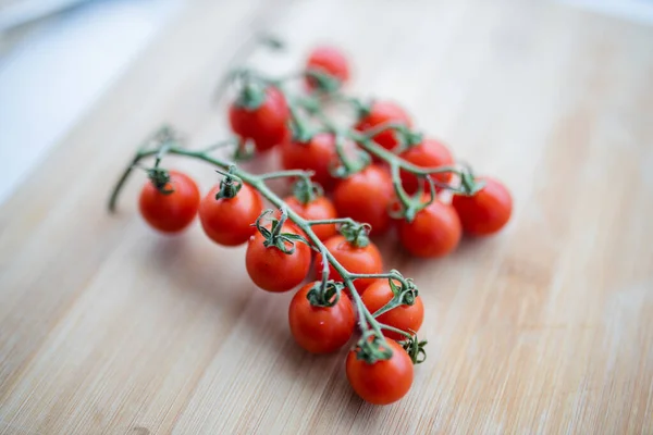 Ramo de tomates cherry en una tabla de cortar — Foto de Stock