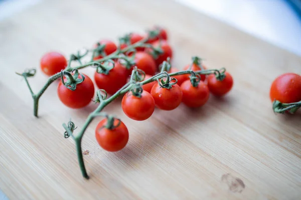 Ramo de tomates cherry en una tabla de cortar — Foto de Stock