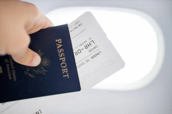 Mężczyzna ręka posiadający amerykański paszport i bilet lotniczy — Zdjęcie stockowe