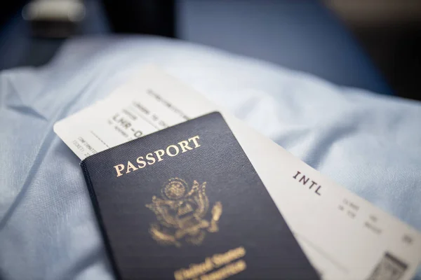 Pasaporte americano y billete de avión encima de un asiento — Foto de Stock