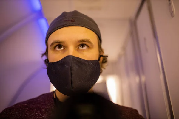 Auto-retrato de um homem usando máscara facial no banheiro do avião — Fotografia de Stock