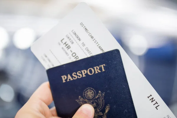 Mano masculina con pasaporte americano y billete de avión — Foto de Stock