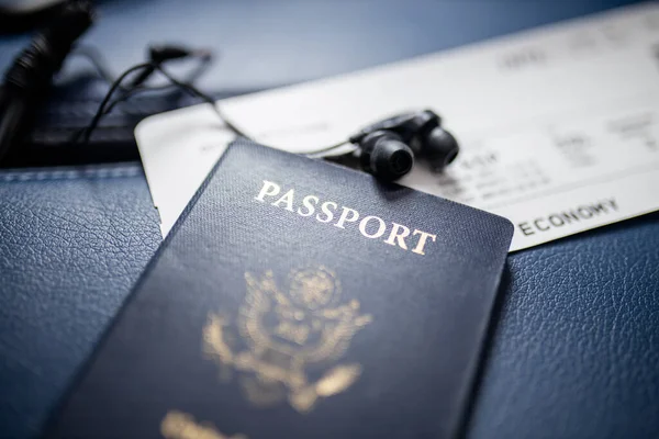 Passaporte americano, bilhete de avião e fone de ouvido acima de um assento — Fotografia de Stock