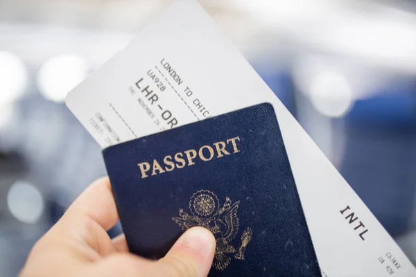 Mano masculina con pasaporte americano y billete de avión — Foto de Stock