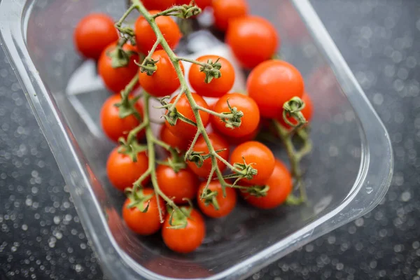 Kers tomaten in een plastic container — Stockfoto