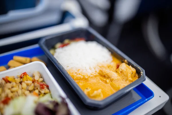 Airplane food on a gray and blue tray from above