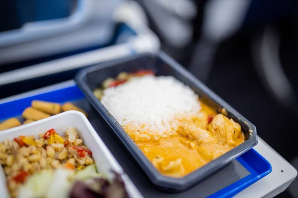 Airplane food on a gray and blue tray from above