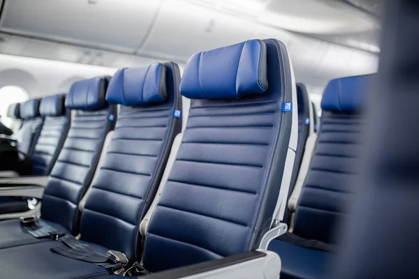 Asientos de avión de pasajeros azul oscuro en la cabina. — Foto de Stock