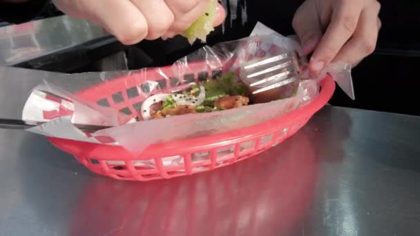 Ruce mačkající citrón nad vegetariánským smaženým taco na plastovém koši — Stock video