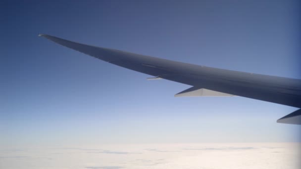 Ala de avión volando sobre un tranquilo lecho de nubes — Vídeo de stock