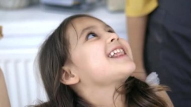 Sevimli küçük kız fıstık ezmesiyle bir dilim ekmek yiyor.