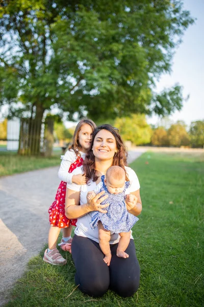 Donna felice e le sue figlie che giocano sull'erba — Foto Stock