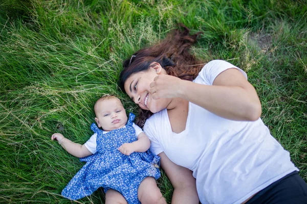 Donna felice e adorabile bambino sdraiato sull'erba — Foto Stock