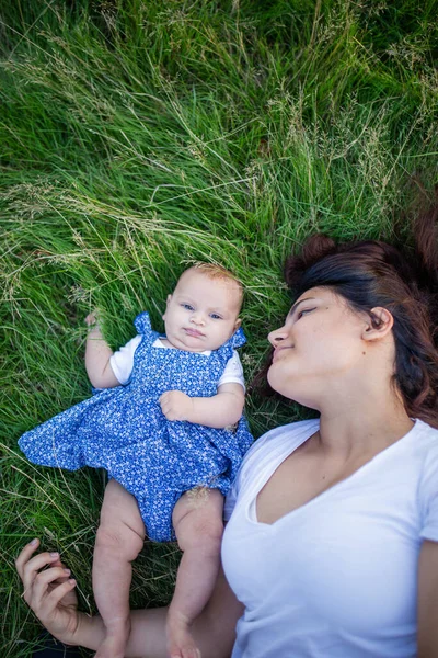 Donna felice e adorabile bambino sdraiato sull'erba — Foto Stock