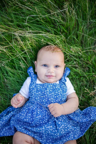 Adorable bebé sonriente acostado en la hierba desde arriba —  Fotos de Stock